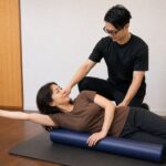 ストレッチポールに背中をあずけ、巻き肩をゆるめる姿勢改善のトレーニング